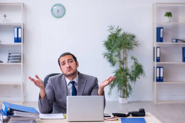 Jovem funcionário masculino infeliz com excesso de trabalho no escritório — Fotografia de Stock