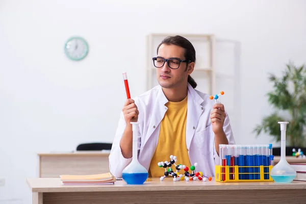 Junger männlicher Chemiker studiert molekulares Modell im Klassenzimmer — Stockfoto