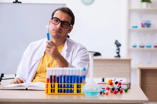 Mladý muž chemik učitel ve třídě — Stock fotografie