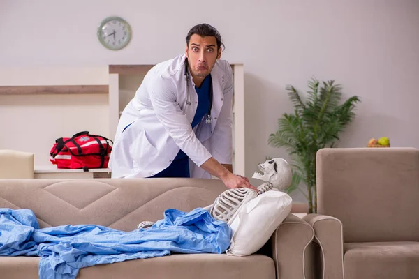 Jeune homme ambulancier visitant le squelette patient — Photo