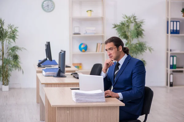 Jonge mannelijke werknemer werkzaam in het kantoor — Stockfoto