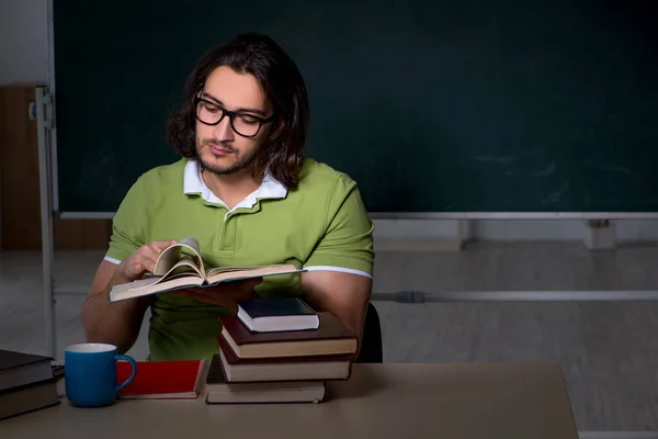 Ung manlig student förbereder sig för tentor i klassrummet — Stockfoto