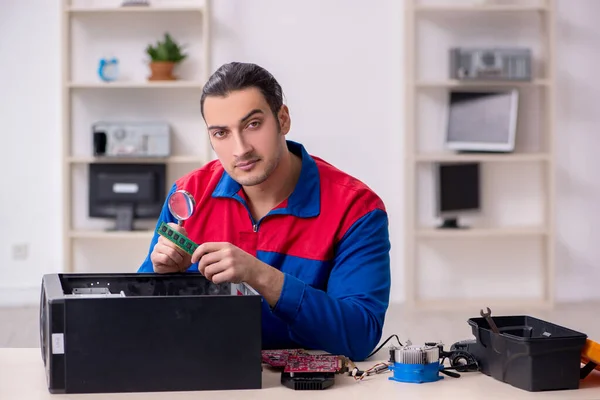 stock image Young male repairman repairing computer