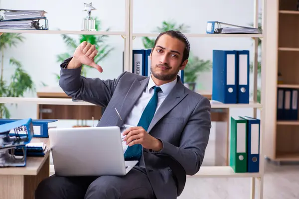 Young male employee and too much work in the office — Stock Photo, Image