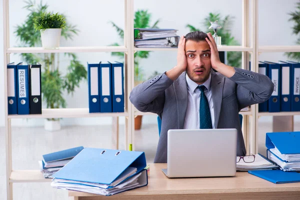 Giovane dipendente maschio e troppo lavoro in ufficio — Foto Stock