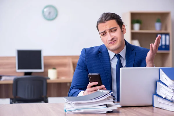 Joven empleado masculino infeliz con el trabajo excesivo — Foto de Stock