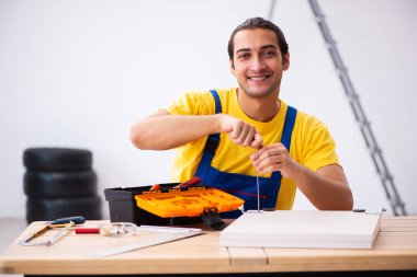 Genç erkek marangoz içeride çalışıyor.