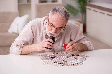 Yaşlı hasta adam evde acı çekiyor.