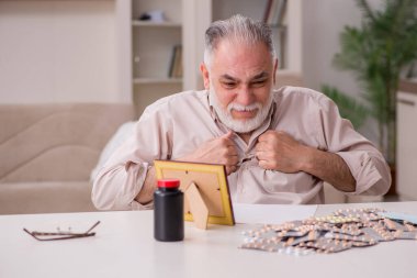 Yaşlı hasta adam evde acı çekiyor.