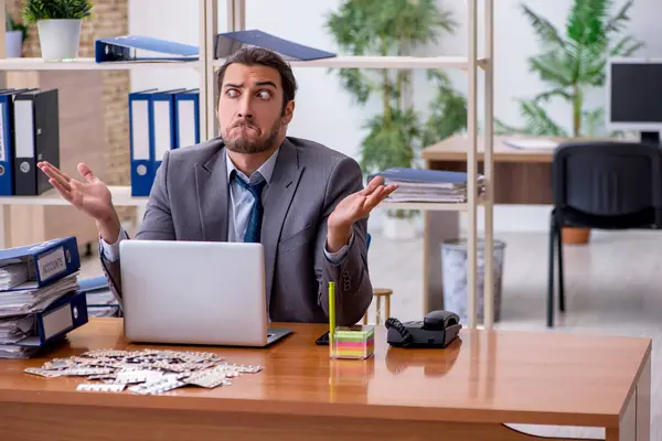 Joven trabajador enfermo masculino que sufre en el lugar de trabajo —  Fotos de Stock