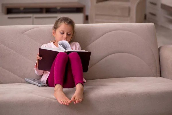 Klein meisje lezen boek thuis — Stockfoto