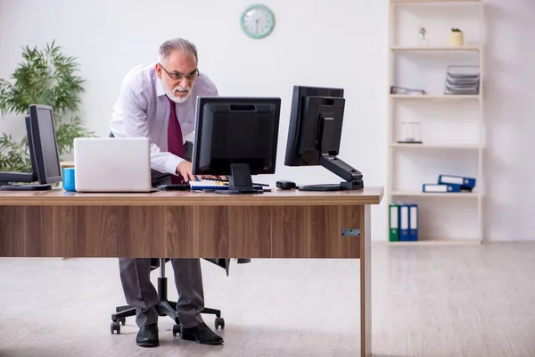 Velho chefe masculino sentado na área de trabalho no escritório — Fotografia de Stock