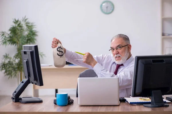 Alte männliche Chefin sitzt am Schreibtisch im Büro — Stockfoto