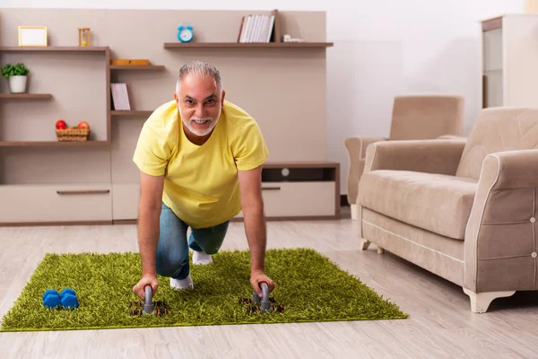 Yaşlı adam evde spor egzersizleri yapıyor. — Stok fotoğraf