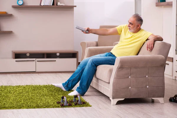 Homem idoso fazendo exercícios esportivos em casa — Fotografia de Stock