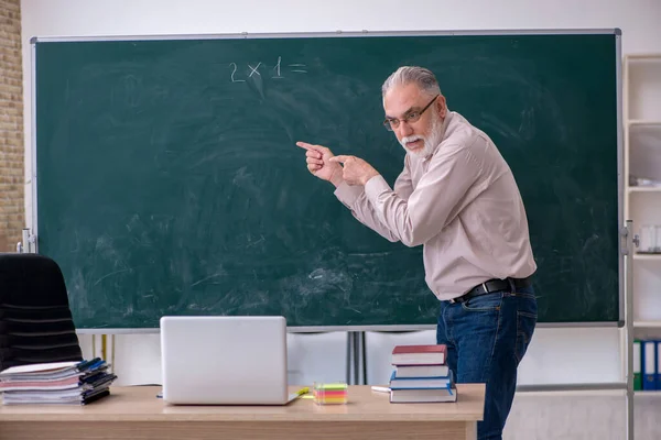 Alte männliche Lehrer sitzen im Klassenzimmer — Stockfoto