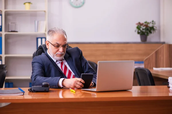 Vecchio dipendente maschio seduto in ufficio — Foto Stock