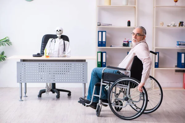 Old man in wheel-chair visiting dead doctor — Stock Photo, Image