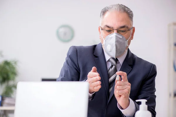 Velho funcionário chefe do sexo masculino trabalhando durante a pandemia — Fotografia de Stock