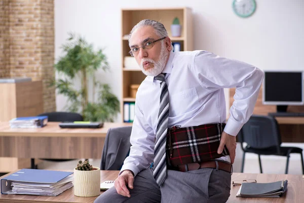 Alter männlicher Mitarbeiter leidet an Radikulitis am Arbeitsplatz — Stockfoto