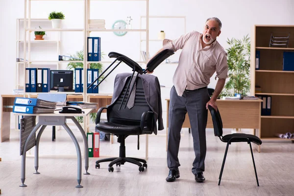 Velho funcionário do sexo masculino fazendo exercícios físicos no local de trabalho — Fotografia de Stock