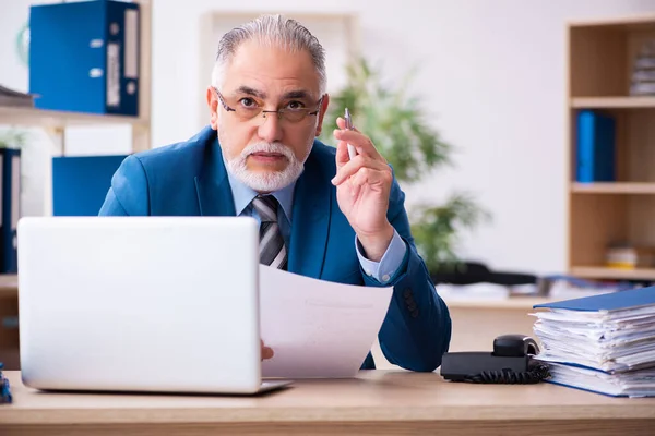 Vieux comptable masculin mécontent du travail excessif sur le lieu de travail — Photo