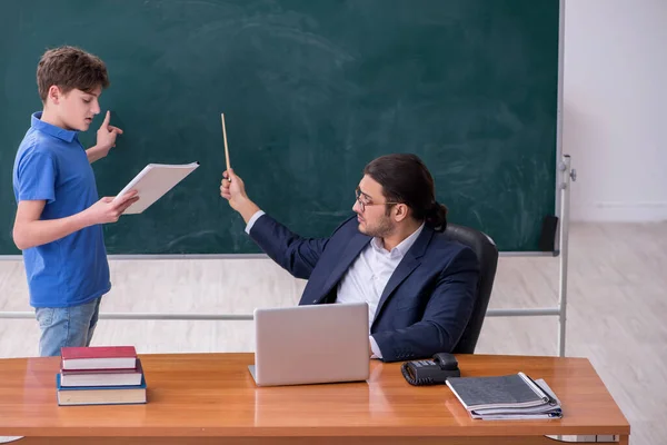 Jovem professor e estudante na sala de aula — Fotografia de Stock