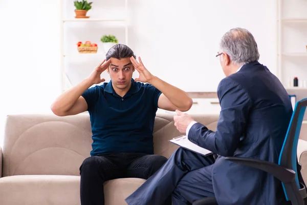 Young man visiting old male psychologist — Stock Photo, Image