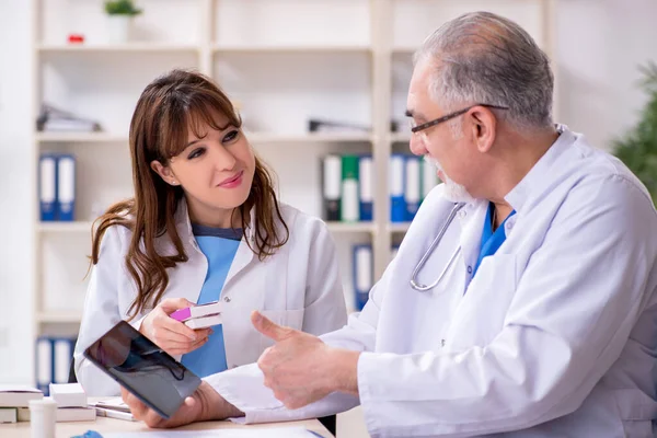 Viejo médico radiólogo masculino y su joven asistente femenina en th — Foto de Stock