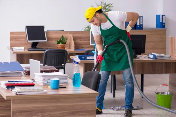 Jonge mannelijke aannemer schoonmaken van het kantoor — Stockfoto