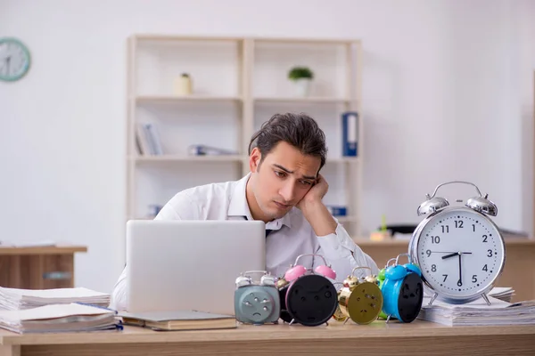 Mladý muž zaměstnanec se bojí zmeškání termínu na pracovišti — Stock fotografie