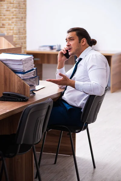 Joven empleado masculino descontento con el trabajo excesivo en la oficina —  Fotos de Stock