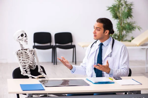 Joven doctor y paciente esqueleto en la clínica —  Fotos de Stock