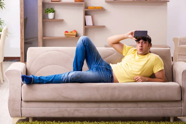 Evde sanal gözlüklü genç bir öğrenci.