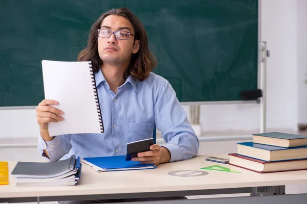 Junger männlicher Lehrer vor grünem Brett — Stockfoto