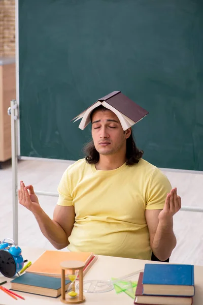 Jovem estudante se preparando para exames em sala de aula — Fotografia de Stock