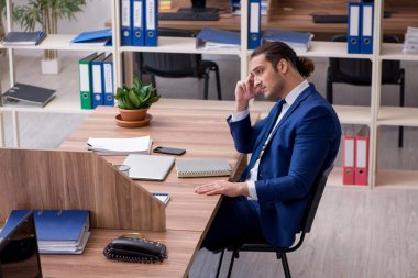 Ofiste çalışan genç bir erkek.