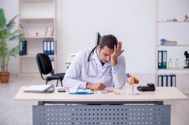 Klinikte çalışan genç bir erkek kardiyolog.