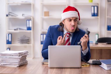 Noel arifesinde ofiste çalışan genç bir erkek işçi.