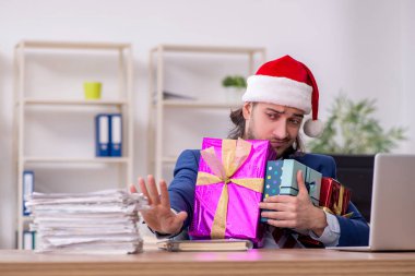 Noel arifesinde ofiste çalışan genç bir erkek işçi.