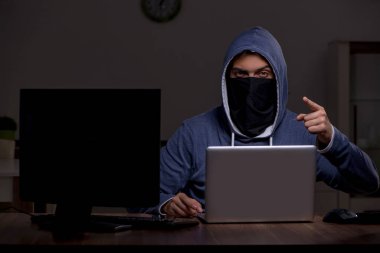 Erkek bilgisayar korsanı, güvenlik duvarını geç saatlerde hackliyor.