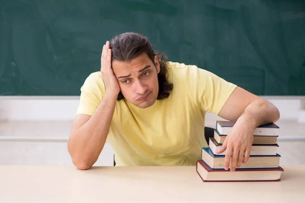 Joven estudiante masculino preparándose para los exámenes en el aula — Foto de Stock