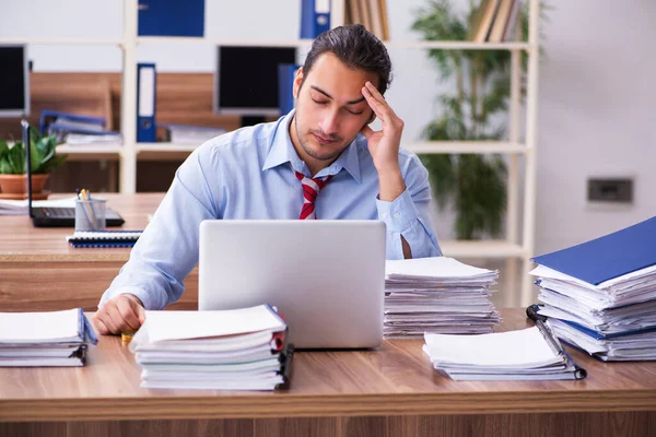 Jonge mannelijke werknemer ongelukkig met overmatig werk — Stockfoto