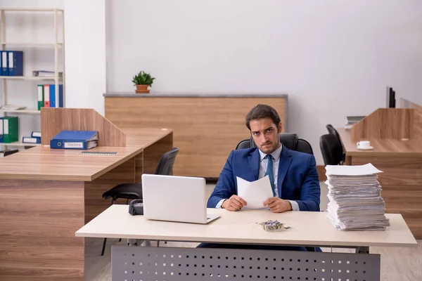 Mladý muž zaměstnanec čtení smlouvy na pracovišti — Stock fotografie