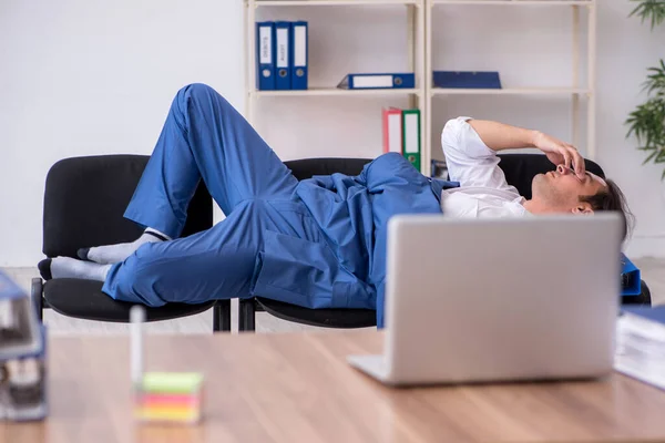 Young male employee sleeping in the office on chairs — Stock Photo, Image