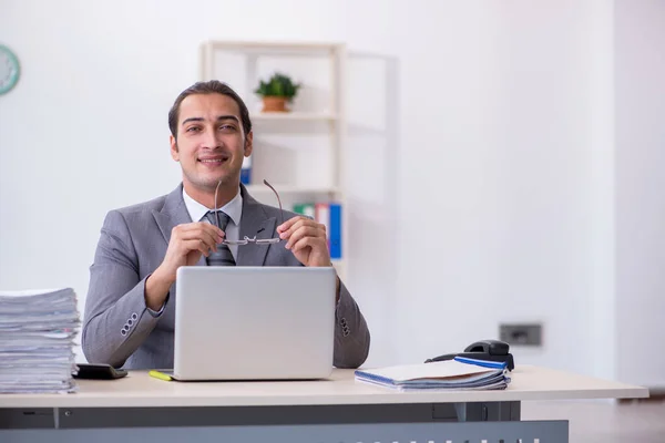 Jovem funcionário masculino infeliz com excesso de trabalho no escritório — Fotografia de Stock