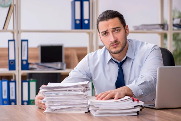 Joven empleado masculino infeliz con el trabajo excesivo — Foto de Stock