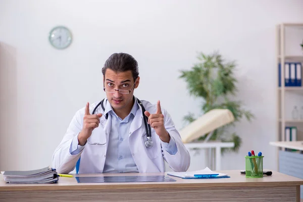 Ung manlig läkare som arbetar på kliniken — Stockfoto