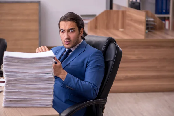 Junge männliche Angestellte unzufrieden mit exzessiver Arbeit im Büro — Stockfoto