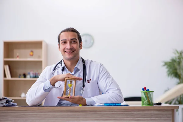 Young male doctor in time management concept — Stock Photo, Image